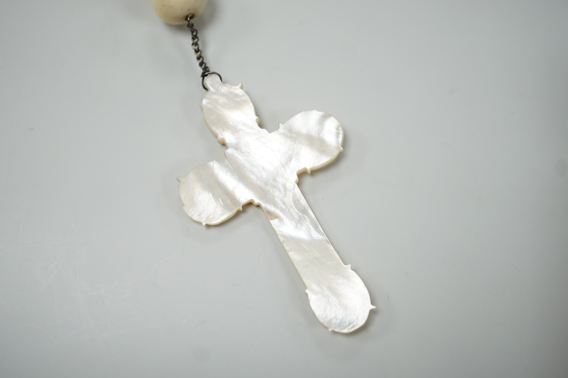A long mother of pearl rosary, 158cm, with carved mother of pearl crucifix pendant, 8cm.